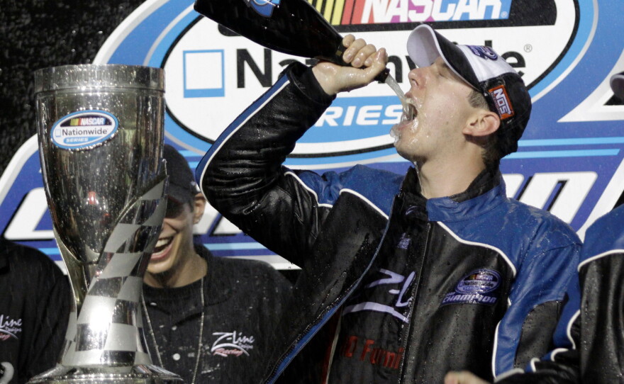 Kyle Busch drinks champagne after winning the Nationwide series championship and the NASCAR Ford 300 Nationwide series auto race at the Homestead-Miami Speedway in Homestead, Fla., on Nov. 21, 2009.