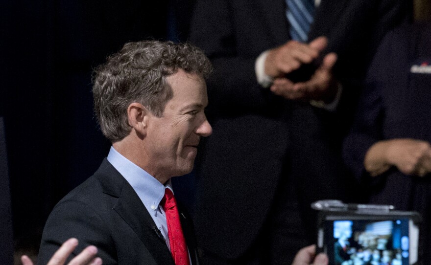 Ron Paul looks on as Rand, a Kentucky senator, arrives for the announcement of his presidential campaign.