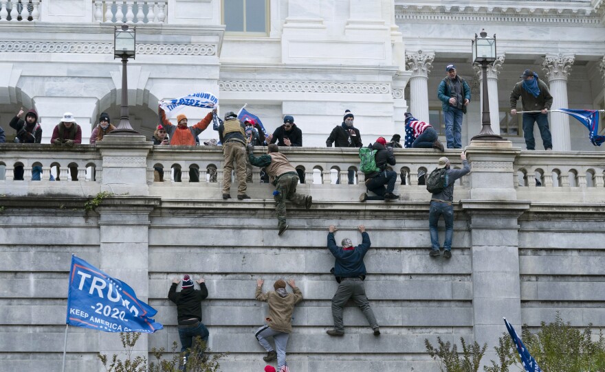 Supporters of President Donald Trump climb the west wall of the the U.S. Capitol on Jan. 6.