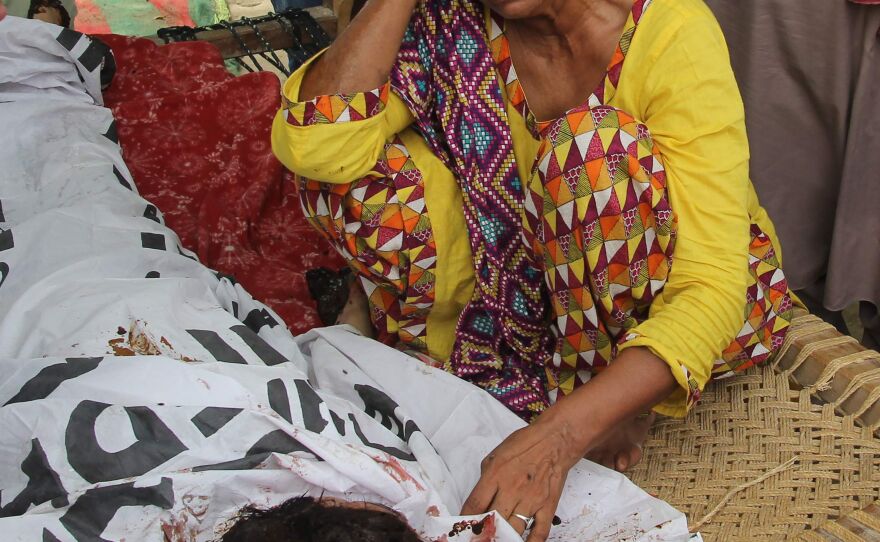 Anwar Bibi, Qandeel Baloch's mother, mourns alongside her daughter's body during her funeral in Punjab's Shah Sadar Din village on July 17.