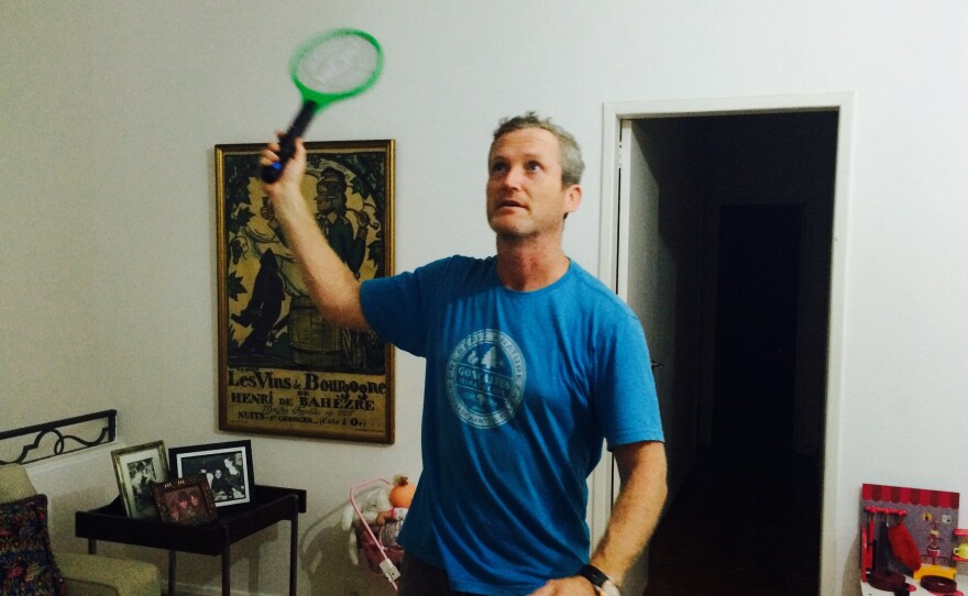 James Hider, the reporter's husband, wields the zapping racket to kill some pesky mosquitoes at their home in Rio de Janeiro, Brazil.
