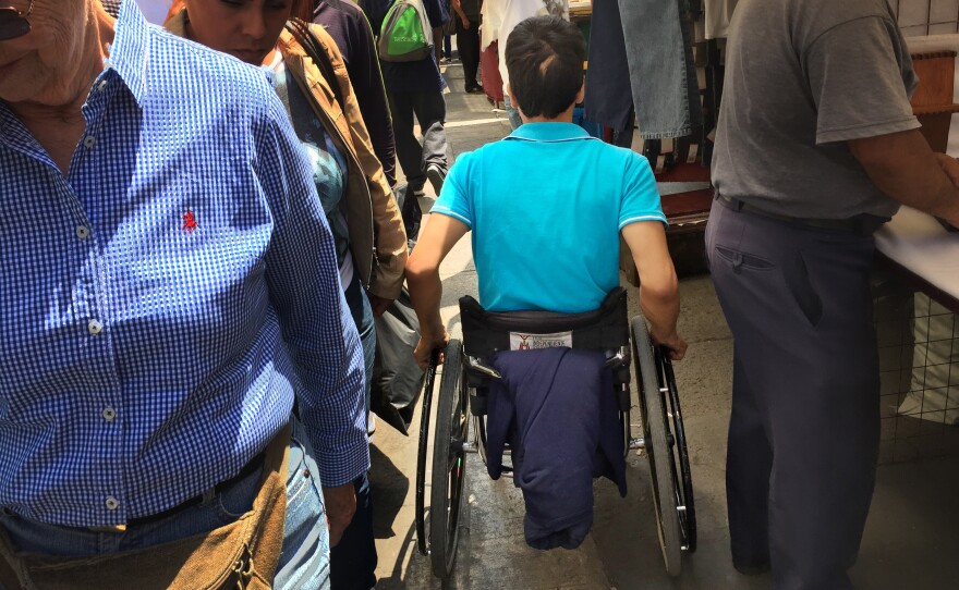 Jasson Garcia squeezes between pedestrians and street stalls in downtown Mexico City.