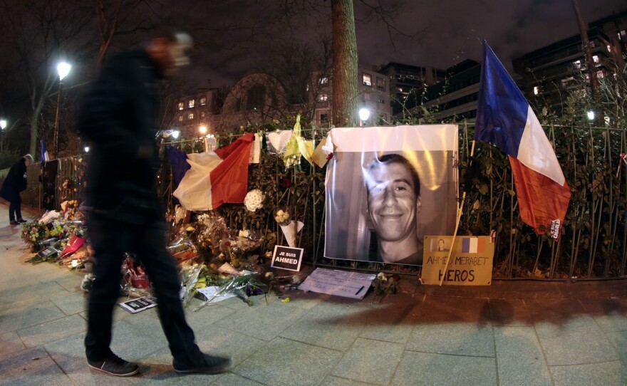 A man walks past a makeshift memorial for French Muslim policeman Ahmed Merabet near the site where he was shot dead by gunmen close to the headquarters of the French satirical weekly Charlie Hebdo.