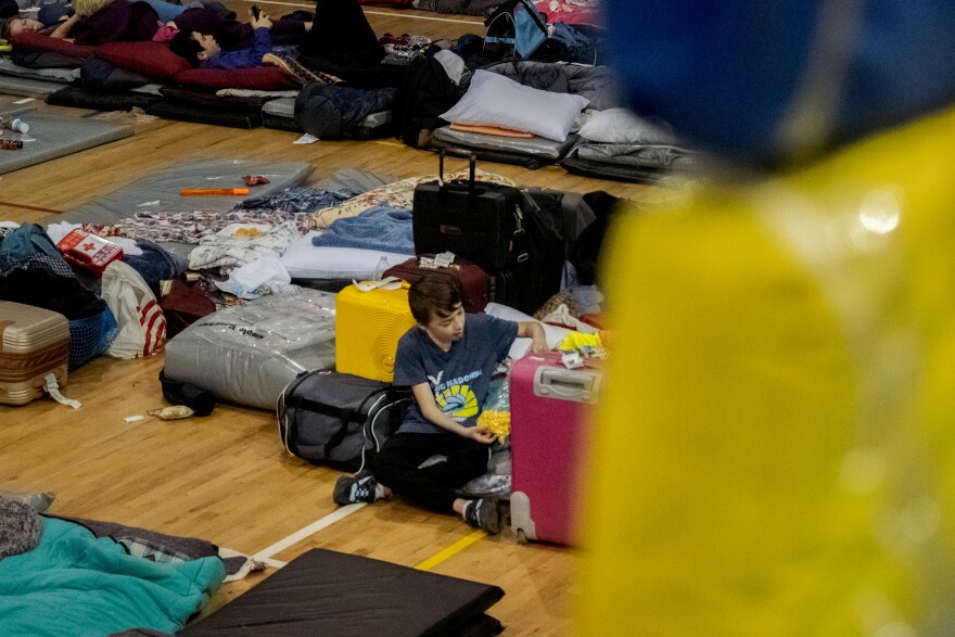 A young Ukrainian war refugee boy sits on his mat at Tijuana's "Unidad Deportiva Benito Juárez" as he and his family wait for their turn to claim asylum in the United States, April 4, 2022.<br/>