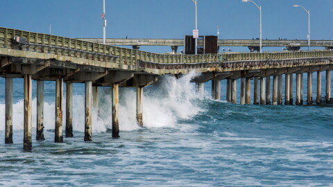 Waves crash under the Ocean Beach Pier on June 10, 2026.