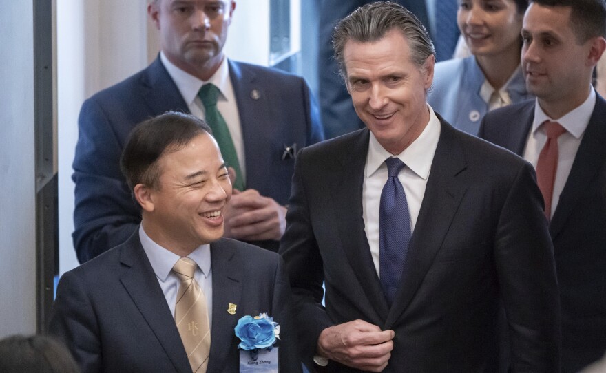 Visiting California Gov. Gavin Newsom, right, and President and Vice-Chancellor of the University of Hong Kong Xiang Zhang, left, arrive at the fireside chat at the Hong Kong University in Hong Kong, Monday, Oct. 23, 2023.
