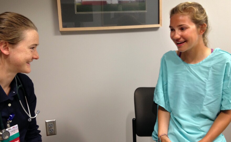Third-year medical student Allie Tetreault, left, talks with Gabrielle Nuki, 16, at Maine Medical Center in Portland, Maine. Gabrielle helps med students practice patient care.