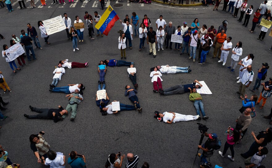 Health workers form a human chain reading "SOS" during a protest for the lack of medicines, medical supplies and poor conditions in hospitals, in Caracas on Aug. 2.