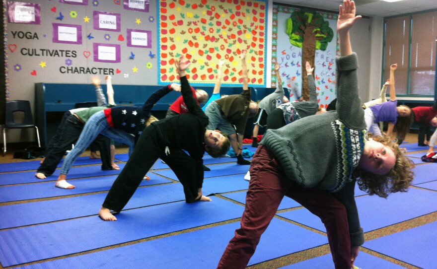 Third graders at Olivenhain Pioneer Elementary School do the Triangle pose during one of their bi-weekly yoga classes, Dec. 18, 2012.