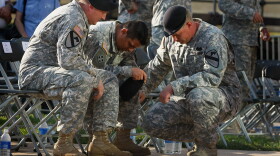 U.S. Army soldiers grieve together during the memorial service in honor of the thirteen victims of the shooting rampage allegedly by U.S. Army Major Nidal Malik Hasan on November 10, 2009 in Fort Hood, Texas.
