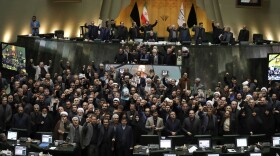 Iranian lawmakers chant slogans as some of them hold posters of Gen. Qassem Soleimani, who was killed in Iraq in a U.S. drone attack, in an open session of parliament, in Tehran, Iran, Tuesday, Jan. 7, 2020. 