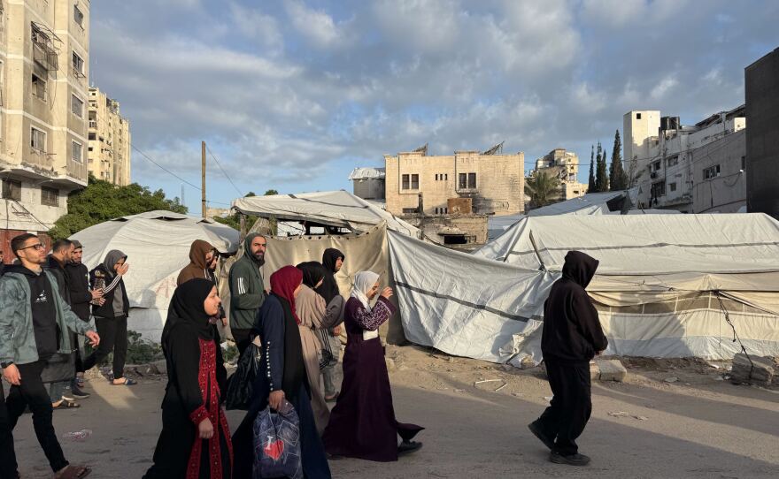 People walk past tents in Gaza City on Friday as Palestinians there celebrated Eid.