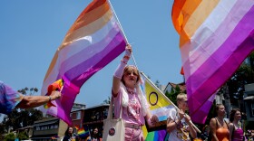 A San Diego Pride Parade goer waves the lesbian Pride flag, July 16, 2022.