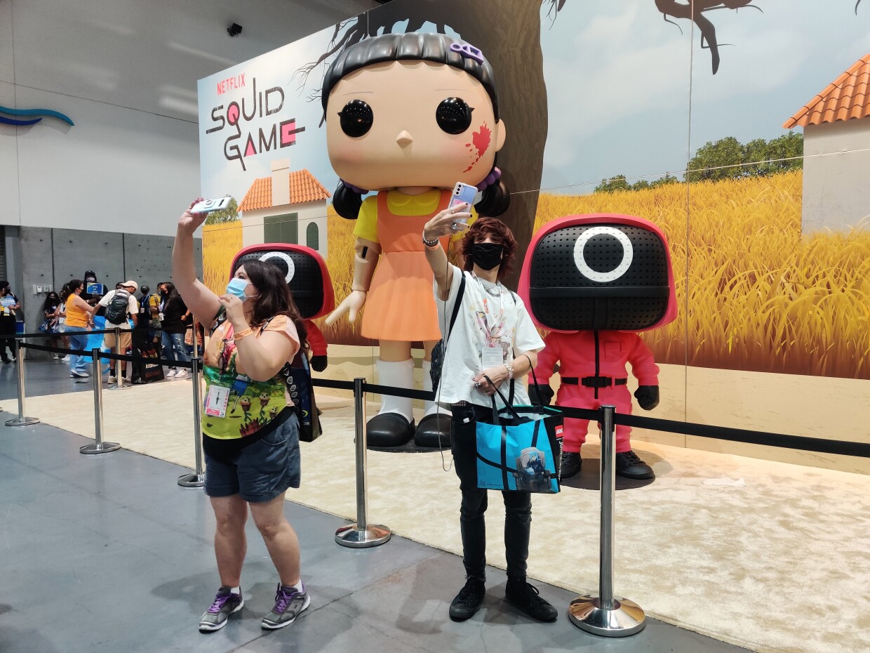 Fans take selfies with Netflix's Squid Game characters inside Comic-Con's Exhibit Hall, July 24, 2022.