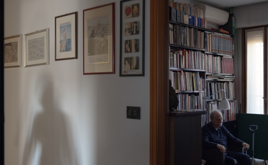 Caregiver Maria Oleksiivna Fedoryshyn's shadow appears as she goes to the kitchen to prepare the lunch for Tommaso, the man she cares for, in Bologna, Italy, in December 2022. Maria was vital in supporting Tommaso and his family when he returned from the hospital after he had a stroke, helping him recover and supporting his wife and son. Maria has lived in Italy for 20 years.
