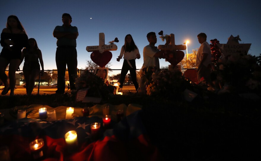 People visit a makeshift memorial outside Marjory Stoneman Douglas High School in Parkland, Fla., where 17 students and faculty were killed in a mass shooting on Feb. 14.