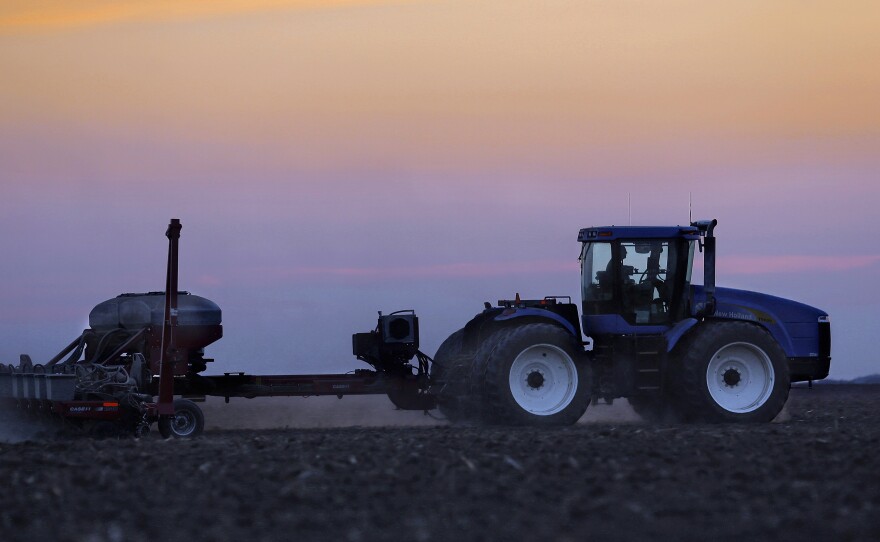 A central Illinois farmer plants corn seed into the evening in Farmingdale, Ill.