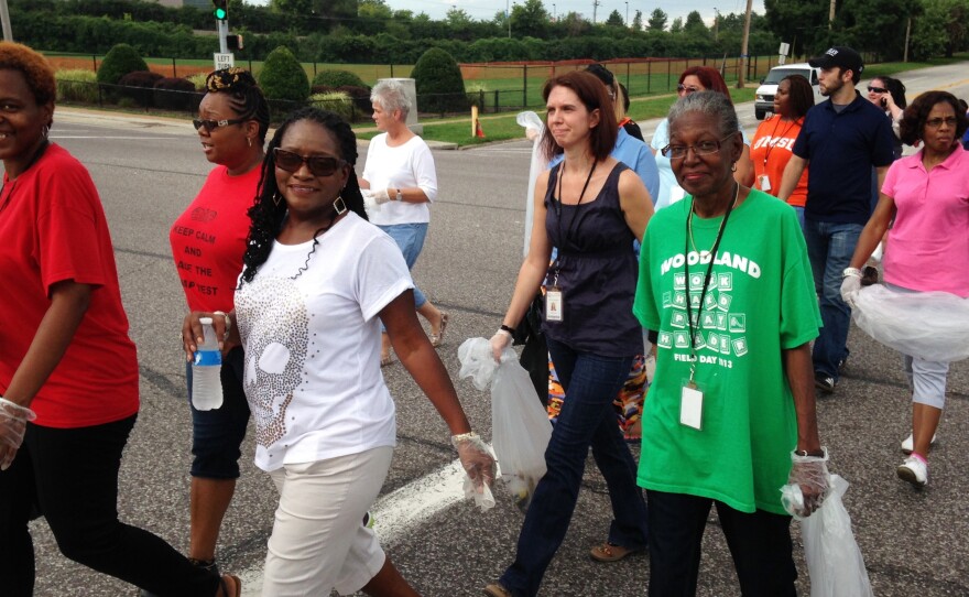 Jennings School District teachers pick up trash Tuesday on West Florissant Avenue in Ferguson, Mo., the scene of nightly police clashes. Jennings and neighboring Ferguson school districts have canceled class due to ongoing unrest.