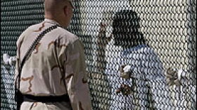 A guard talks with a Guantanamo detainee in an April 2007 file photo. The Supreme Court has agreed to review whether detainees at the U.S. prison camp in Cuba can challenge their confinement in federal court.