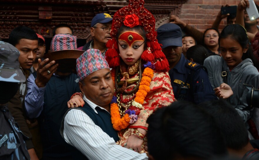 Nepal's Living Goddess, the Kumari Devi, 9, observes a chariot festival in Kathmandu on March 29. The goddess is worshipped by both Hindus and Buddhists. She's selected as a young child and lives an isolated and secretive existence and is rarely seen in public. Her historic home survived last month's earthquake with only minor cracks. She's being held by her caretaker Gautam Shakya.