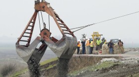 A load of rocks is dropped to patch a crater as repairs are made on the Tyler Island levee near Isleton, Calif., Feb. 15, 2017.  