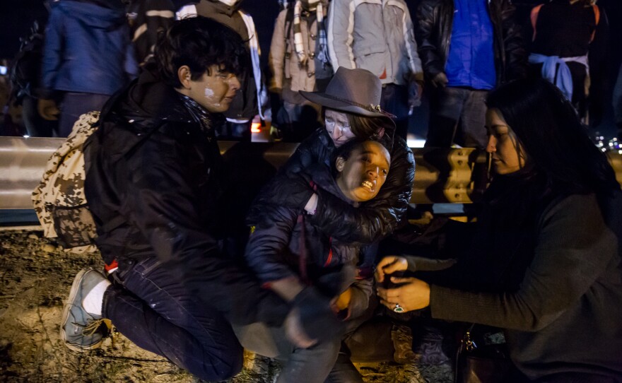 American activists comfort a migrant mother during a tear gas incident at the border fence, Jan. 1, 2018. 