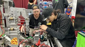 Jeremiah Jeffries (left) coaches robotics driver, Julio Flores, 17, in some maintenance on the Lincoln High School team's 125-pound robot in Houston, Texas, April 17, 2024. 