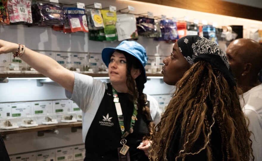 An employee points out product at Mankind Dispensary in San Diego on Wednesday, Aug. 7, 2024.