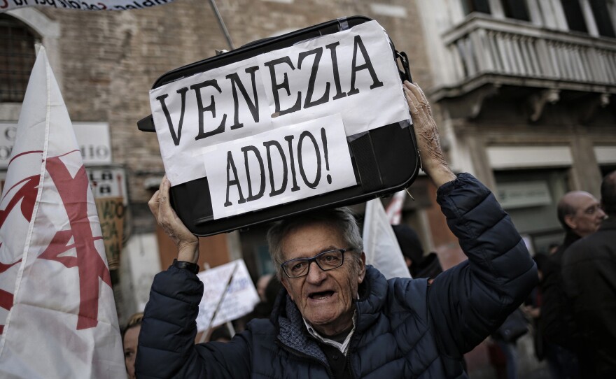 A man holds a suitcase saying "Goodbye Venice!" during a Nov. 12 demonstration against the increasing number of tourists.