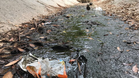 Trash lies in a storm water channel that empties onto Tourmaline Surfing Park in northern Pacific Beach, June 25, 2018.