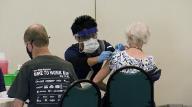 A woman gets a vaccination at the new National City site, Jan. 21, 2020.