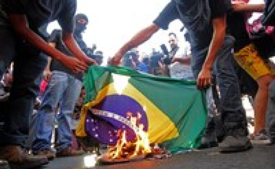 Demonstrators burn a Brazilian flag in protest of the upcoming FIFA World Cup in Goiania, Brazil, on Tuesday.