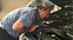 Edward Agababian inspects a car engine in this undated photo.