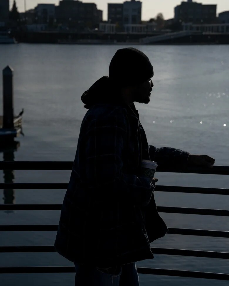 J.M., who prefers to use his initials for privacy, looks out at the San Francisco Bay at Jack London Square, where he walks almost daily for exercise and because he enjoys looking at the water, in Oakland on Dec. 1, 2025. JM received housing support through CARE Court and now lives within walking distance of Jack London.