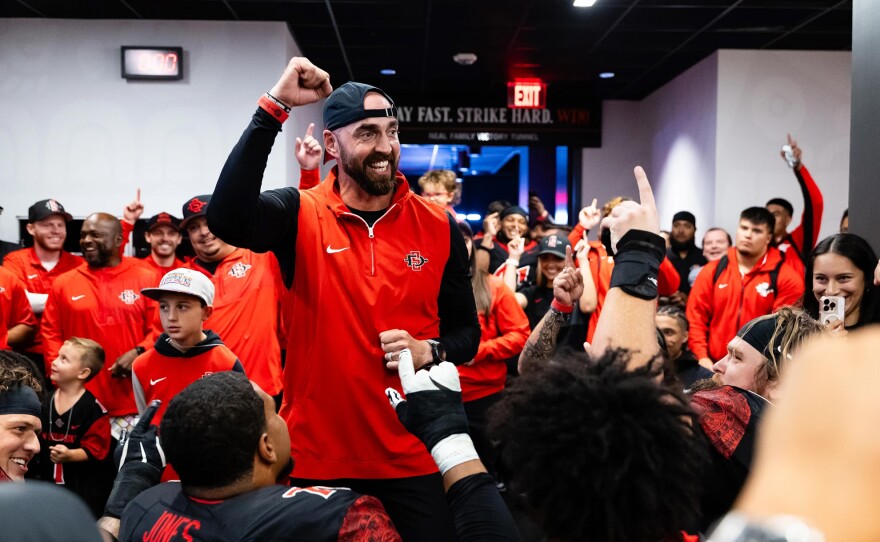 San Diego State football coach Sean Lewis celebrates with the team after becoming bowl eligible for the first time in three years on Oct. 25, 2025 in Fresno, Calif.