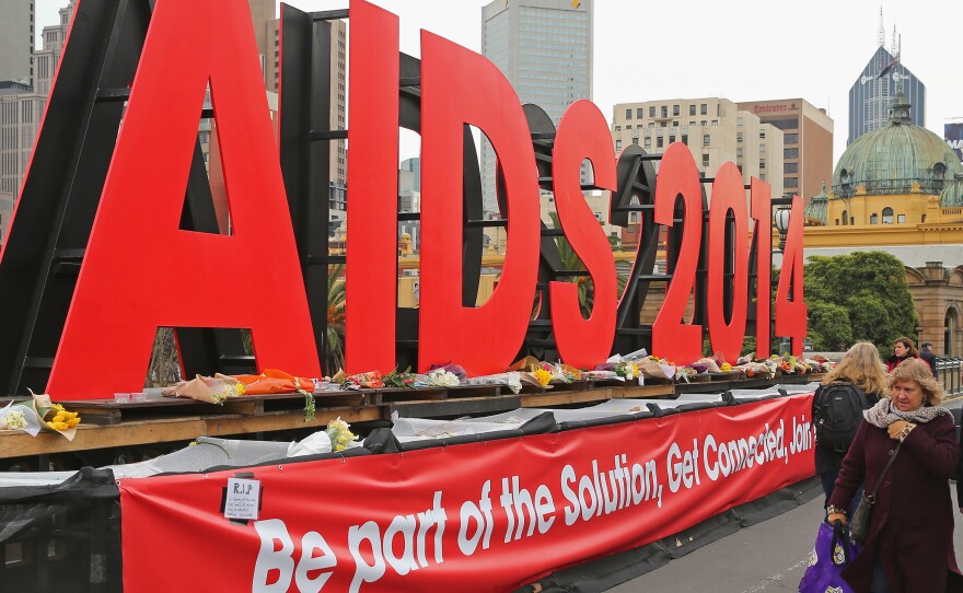 People walk past tributes to the victims of MH17, placed on signage for the 20th International AIDS Conference in Australia in 2014. Several AIDS activists on their way to the conference were killed.