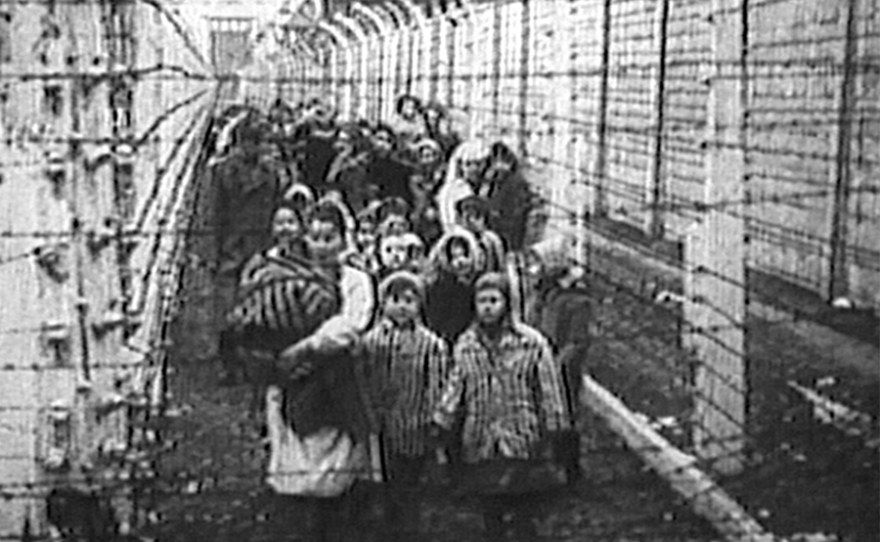 Eva Kor, front middle, and her twin Miriam lead a procession of children between the fences at Auschwitz for the iconic Russian liberation footage. (undated photo)