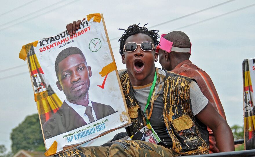 A supporter holds a poster of musician-turned-politician Robert Kyagulanyi, better known as Bobi Wine, in a suburb of Kampala on June 29, 2017. Wine was imprisoned and allegedly tortured following a demonstration against Ugandan President Yoweri Museveni, prompting prominent artists to issue an open letter calling for his release.