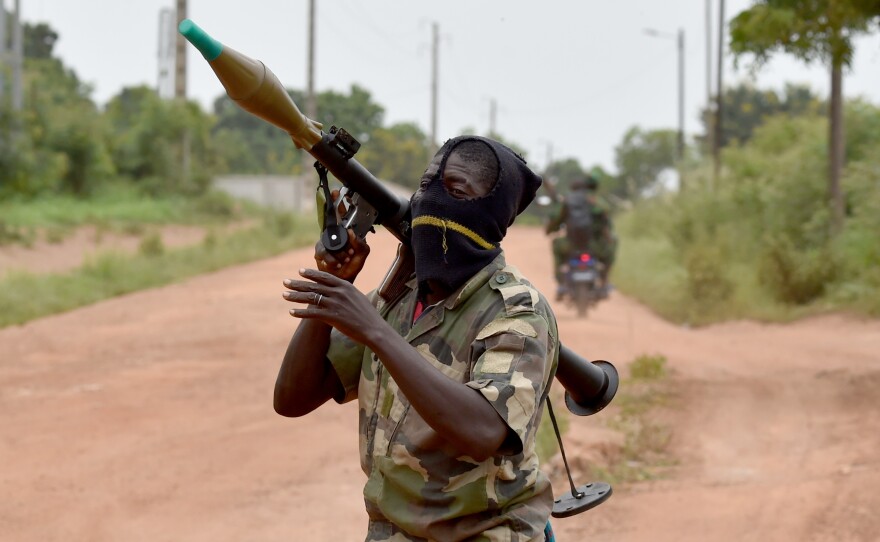 A soldier bears a rocket launcher near a military camp in the city of Bouake on Monday. Once the stronghold of the rebels that brought President Alassane Ouattara to power in 2011, Bouake is now a centerpiece of the unrest among soldiers who feel cheated of bonus pay.
