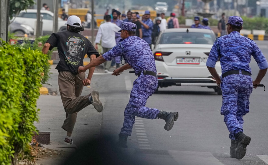Security personnel detain a protester during a demonstration by the Cockroach Janta Party demanding the resignation of Chief Election Commissioner Gyanesh Kumar in New Delhi, India, Saturday, Oct. 10, 2026.