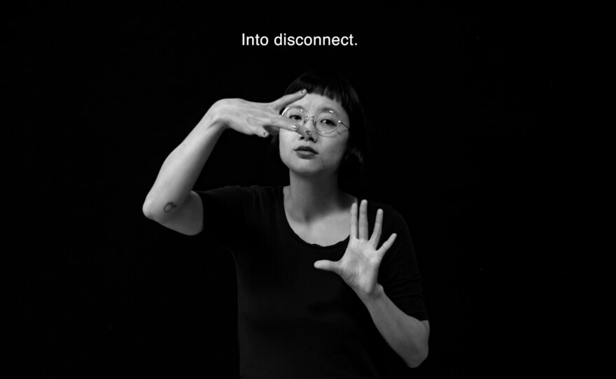 Christine Sun Kim signs in American Sign Language the word 'disconnect.'