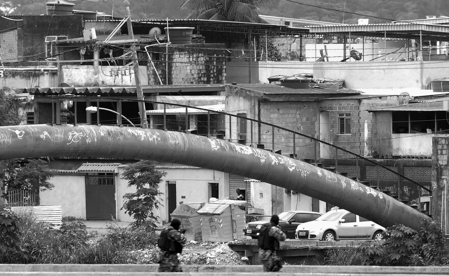 Paramilitary police monitor a checkpoint on a bridge in the City of God favela on July 21.