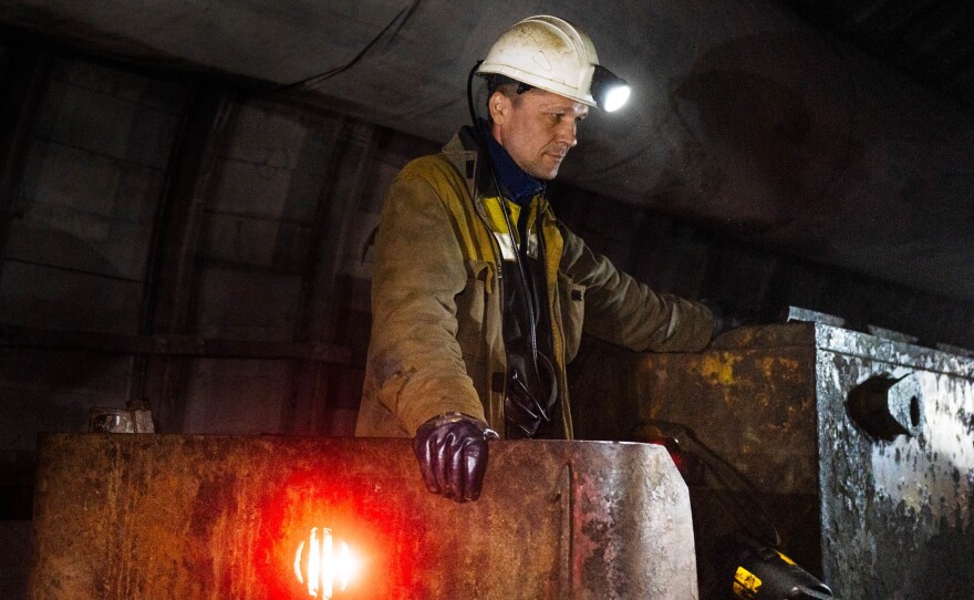 A mine railway operator in Eastern Ukraine waits as workers disembark. Russia's invasion of Ukraine disrupted global supplies of fossil fuels and led to more reliance on coal for electricity in some countries. The future sources of energy around the world are major topics at climate negotiations underway in Egypt starting this week.