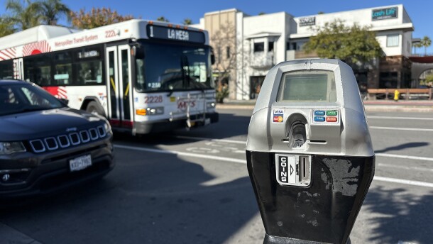 An MTS bus passes by a parking meter on University Avenue in Hillcrest, Dec. 12, 2023.