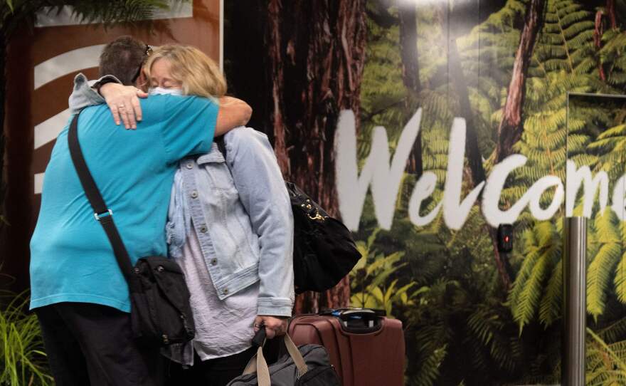 Families are reunited as travelers arrive on the first flight from Sydney in Wellington on Monday after Australia and New Zealand opened a trans-Tasman quarantine-free travel bubble.