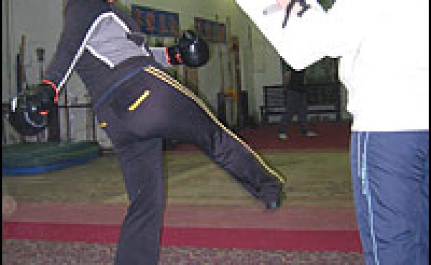 Zhao Xin (left) swings a kick at pads held by classmate Jiang Meng during sparring practice in Changchun, China.