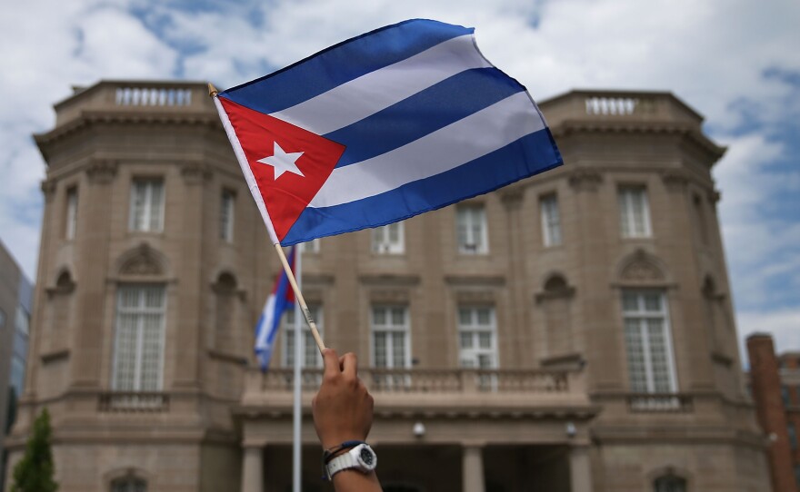 WASHINGTON, DC - JULY 20: A supporter waves a Cuban flag in front of the country's embassy after it re-opened for the first time in 54 years July 20, 2015 in Washington, DC. The embassy was closed in 1961 when U.S. President Dwight Eisenhower severed diplomatic ties with the island nation after Fidel Castro took power in a Communist revolution. (Photo by Mark Wilson/Getty Images)