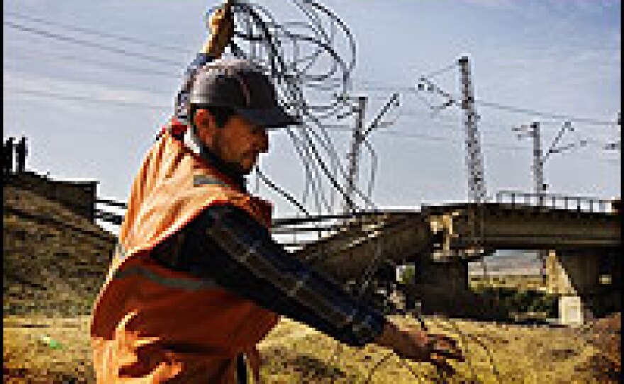 A Georgian railway worker holds the detonating wire next to a bombed railway bridge, linking Georgia's capital Tbilisi to the rest of the country and neighboring states.