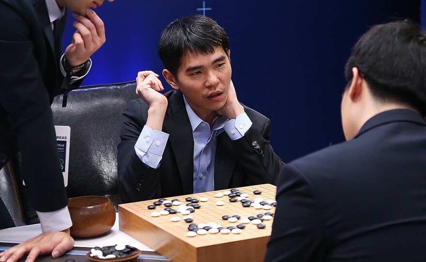 South Korean professional Go player Lee Se-Dol reviews the match with other professional Go players after the fourth match against Google's artificial intelligence program, AlphaGo.