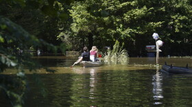Residents paddle through a flooded neighborhood in a kayak in Indianapolis, Sunday, Aug. 16, 2026.